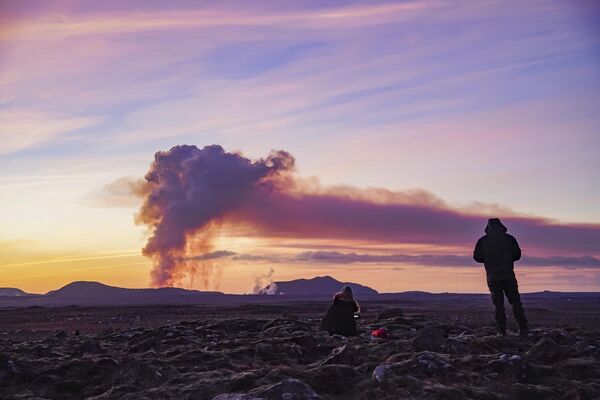 Люди наблюдают с севера за извержением вулкана возле Гриндавика. - Sputnik Таджикистан