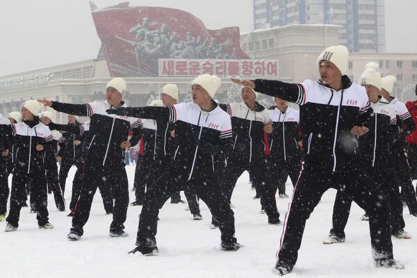 Представители комиссий, министерств и национальных учреждений Северной Кореи играют в тхэквондо на площади Ким Ир Сена в первый спортивный день Нового года в Пхеньяне. - Sputnik Таджикистан