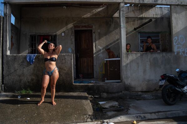 Женщина освежается из шланга на улице во время жары в районе Гуаратиба в Рио-де-Жанейро, Бразилия. По данным мэрии Рио-де-Жанейро, в западной зоне Гуаратибы жара достигло 59,5° Цельсия.  - Sputnik Таджикистан