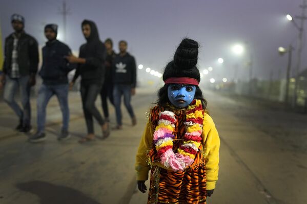 Ребенок, одетый как индуистский бог Шива, просит милостыню во время ежегодной ярмарки Магх Мела в Праяградже, Индия. - Sputnik Таджикистан