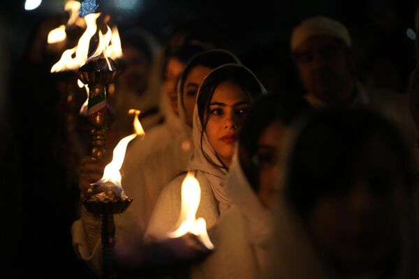 Зороастрийцы несут факелы, чтобы поджечь костер во время церемонии празднования Саде на окраине Тегерана. - Sputnik Таджикистан