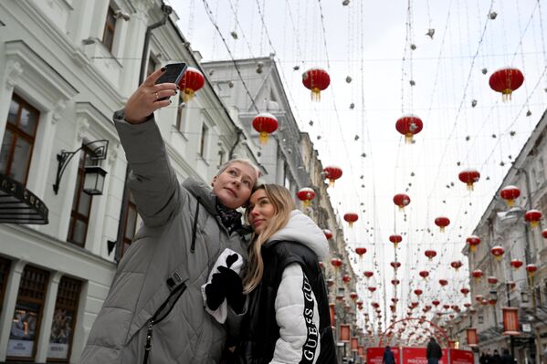 Девушки фотографируются в Камергерском переулке, украшенном в честь празднования китайского Нового года в Москве - Sputnik Таджикистан