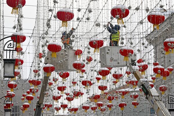 Рабочие устанавливают украшения в Камергерском переулке в честь празднования китайского Нового года в Москве. - Sputnik Таджикистан