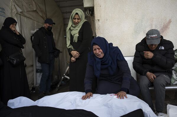 Палестинцы оплакивают родственников, погибших в результате израильской бомбардировки. - Sputnik Таджикистан