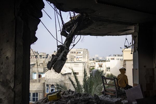Палестинец сидит в своем доме, разрушенном в результате израильского удара, в Рафахе, сектор Газа. - Sputnik Таджикистан