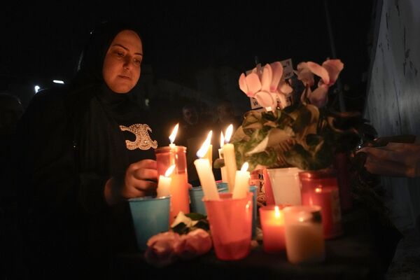 Женщина зажигает свечи возле посольства России в Бейруте, Ливан. - Sputnik Таджикистан