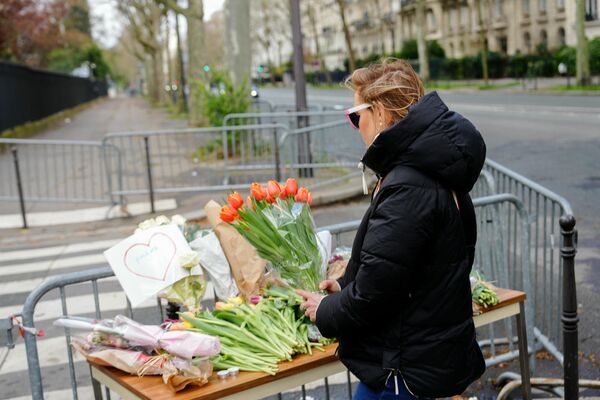 Женщина держит букет цветов перед посольством России в Париже. - Sputnik Таджикистан