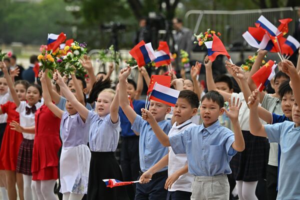 Кӯдакон бо парчамҳои Русия ва Чин ба истиқболи роҳбарони ду кишвар омаданд.  - Sputnik Тоҷикистон