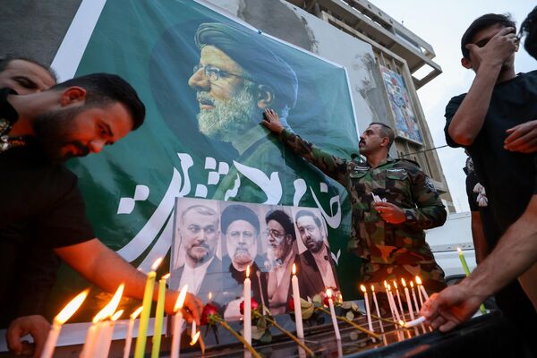 Иракцы возлагают цветы и зажигают свечи в память о покойном президенте Ирана Ибрахиме Раиси. - Sputnik Таджикистан