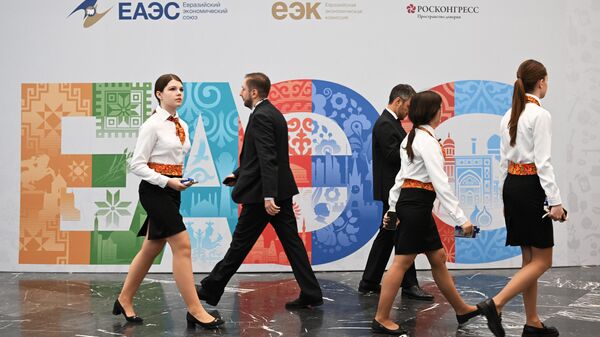  Участники проходят рядом со стендом с символикой Евразийского экономического форума - Sputnik Таджикистан