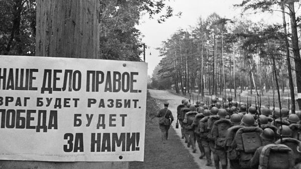 Колонны бойцов движутся на фронт мимо плаката Наше дело правое. Победа будет за нами. Москва, 23 июня 1941 года  - Sputnik Таджикистан