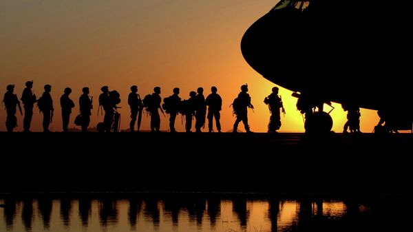 Американские военнослужащие во время посадки в военно-транспортный самолет. Архивное фото - Sputnik Таджикистан