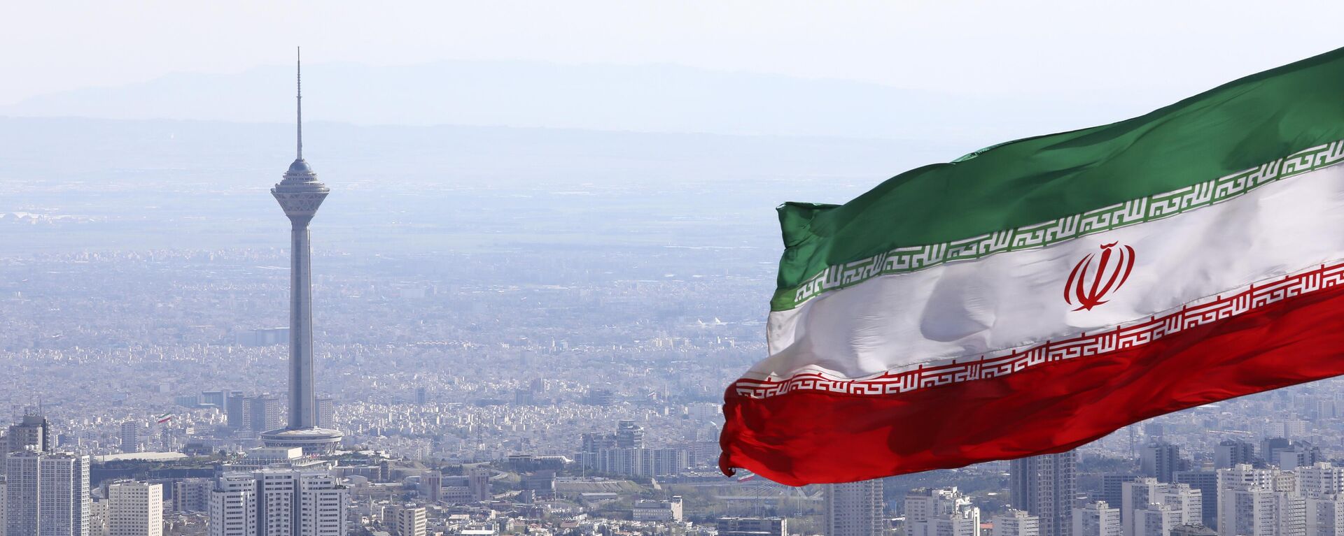 Национальный флаг Ирана над Тегераном.  - Sputnik Тоҷикистон, 1920, 26.06.2024