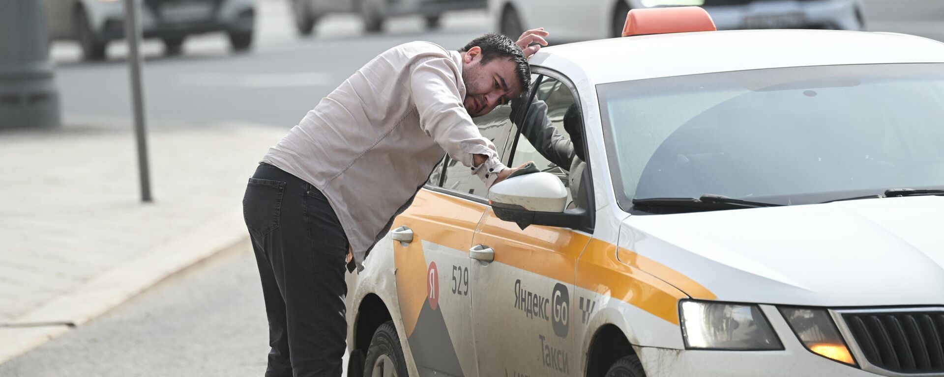 Таксист протирает зеркало машины. - Sputnik Таджикистан, 1920, 29.07.2025