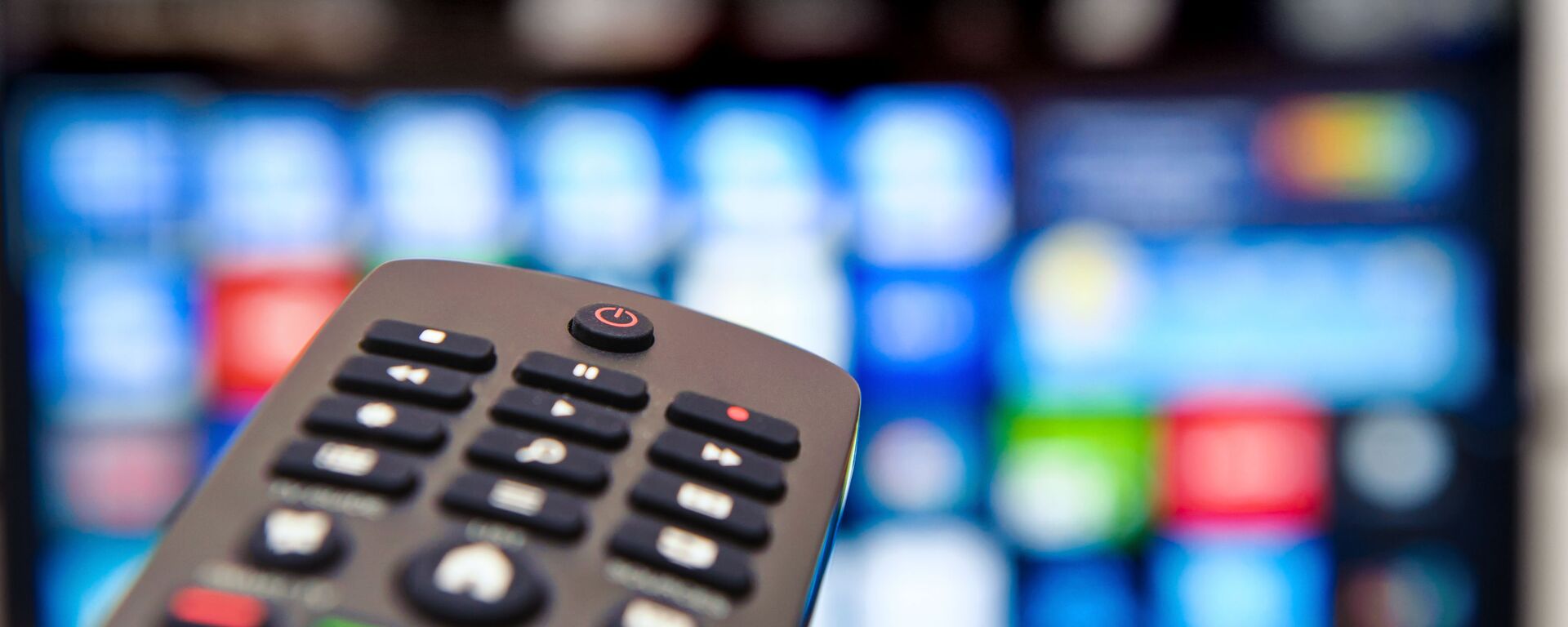 Телевизионный пульт на фоне экрана  - Sputnik Таджикистан, 1920, 02.09.2024