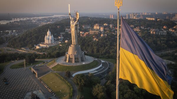 Украинский флаг и монумент Родина-Мать в Киеве  - Sputnik Таджикистан