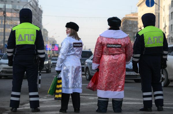 Кормандони БДА дар бо либоси Бобои барфӣ ва ҳангоми баргузории чорабинии “Полис Бобои барфӣ” дар майдони ба номи Ленини шаҳри Новосибирск ронандагонро бо Соли нав табрик мекунанд. - Sputnik Тоҷикистон