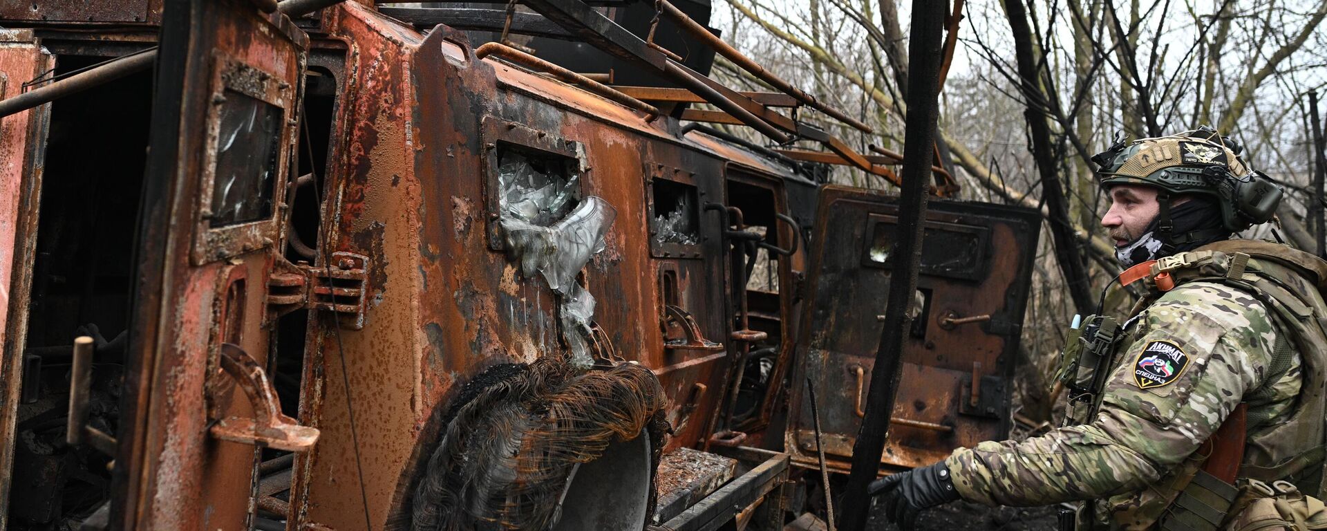 Военнослужащий батальонной тактической группы (БТГР) Каштана спецназа Ахмат возле подбитого бронеавтомобиля Казак в хуторе Бердин в Большесолдатском районе Курской области. - Sputnik Тоҷикистон, 1920, 02.02.2025