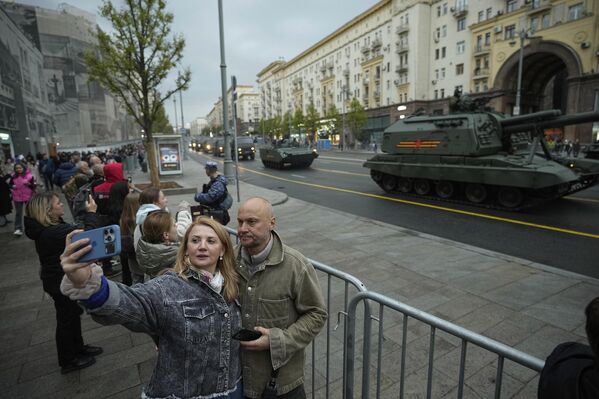 Люди делают селфи на фоне военной техники, проезжающей по Тверской улице в сторону Красной площади. Люди делают селфи на фоне военной техники, проезжающей по Тверской улице в сторону Красной площади. - Sputnik Таджикистан