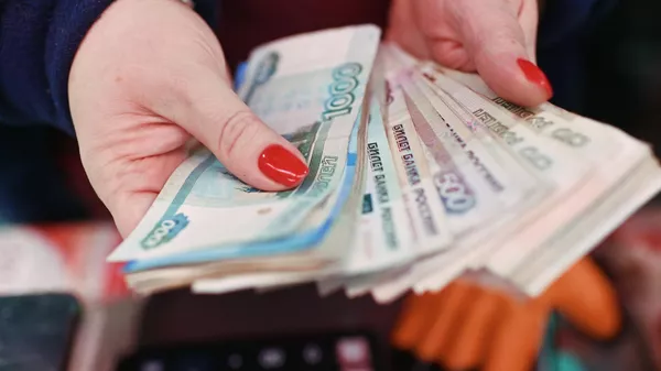 Продавец на рынке пересчитывает деньги. - Sputnik Тоҷикистон
