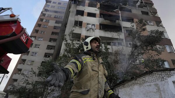 Пожарный на месте взрыва в жилом комплексе на севере Тегерана, Иран  - Sputnik Тоҷикистон