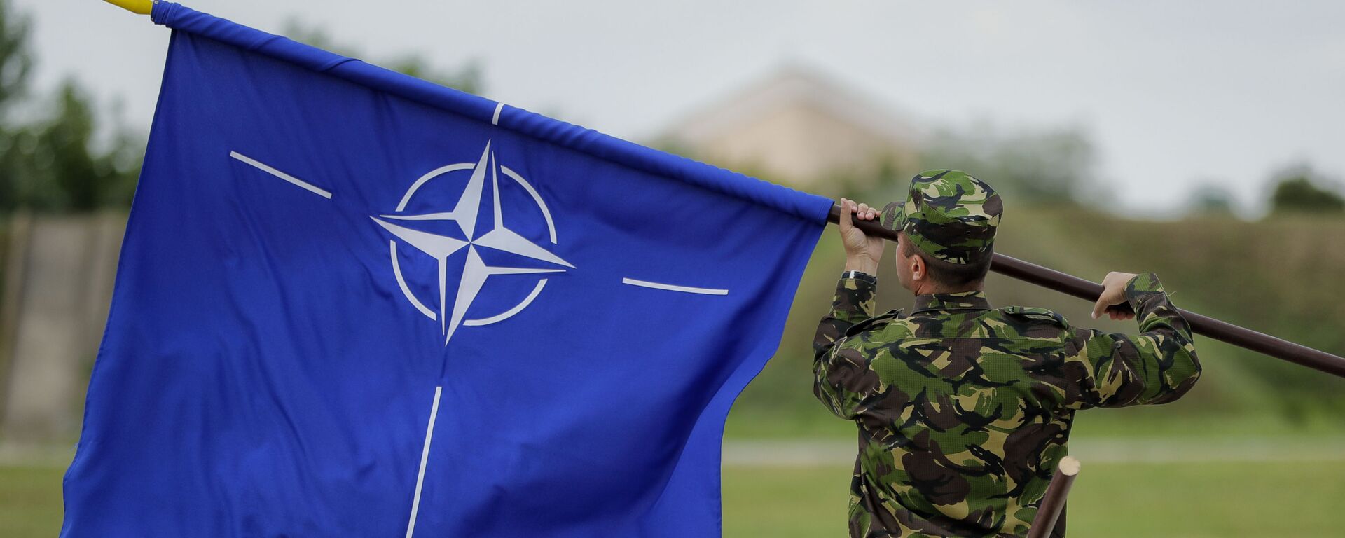 Военнослужащий с флагом НАТО - Sputnik Таджикистан, 1920, 25.06.2025