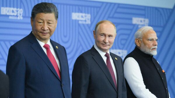 Президент РФ Владимир Путин, председатель КНР Си Цзиньпин и премьер-министр Индии Нарендра Моди на церемонии совместного фотографирования глав делегаций стран БРИКС в рамках XVI саммита БРИКС в Казани. - Sputnik Таджикистан