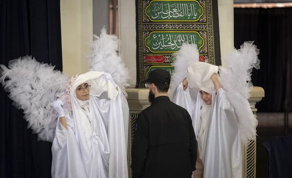 Як мард бо ду зани ҷавоне, ки либоси фариштаҳо доштанд, пас аз анҷоми маросими ёдбуди занону кӯдакони кушташуда дар ҷанги 12-рӯзаи байни Эрон ва Исроил дар масҷиди бузурги Имом Хумайнӣ дар Теҳрон, рӯзи 30 июли соли 2025 суҳбат мекунад. Мақомоти Эрон мегӯянд, ки 110 кӯдак ва зан дар ҳамлаҳои исроилиён дар манотиқи ғайринизомии Эрон кушта шудаанд. Як мард бо ду зани ҷавоне, ки либоси фариштаҳо доштанд, пас аз анҷоми маросими ёдбуди занону кӯдакони кушташуда дар ҷанги 12-рӯзаи байни Эрон ва Исроил дар масҷиди бузурги Имом Хумайнӣ дар Теҳрон, рӯзи 30 июли соли 2025 суҳбат мекунад. Мақомоти Эрон мегӯянд, ки 110 кӯдак ва зан дар ҳамлаҳои исроилиён дар манотиқи ғайринизомии Эрон кушта шудаанд. - Sputnik Тоҷикистон