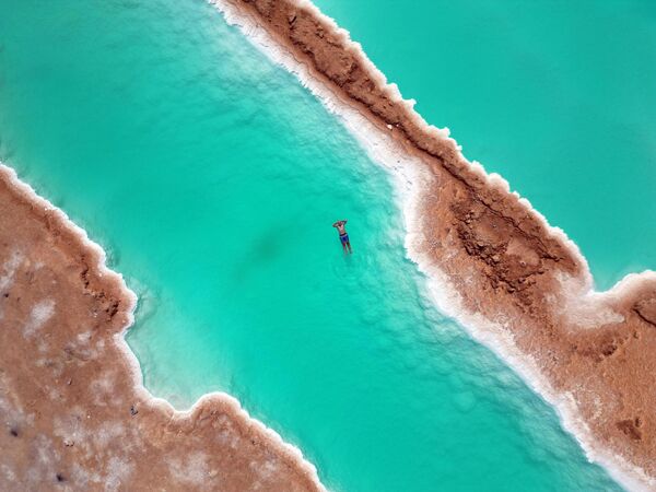 Вид на соляные озера в Сиве, расположенной в самом сердце Западной пустыни Египта. Оазис Сива славится своим историческим наследием и природной красотой. Регион известен древними храмами и традиционной берберской культурой, которая в последние годы становится все более популярной среди местных и иностранных туристов. Соленые озера и горячие песчаные ванны, полезные при кожных заболеваниях, сделали это место популярным оздоровительным направлением. - Sputnik Таджикистан