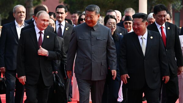 Президент РФ Владимир Путин, председатель КНР Си Цзиньпин и председатель государственных дел КНДР Ким Чен Ын после совместного фотографирования глав иностранных делегаций, приглашенных на торжественные мероприятия по случаю 80-й годовщины Победы китайского народа в войне сопротивления Японии и окончания Второй мировой войны - Sputnik Таджикистан