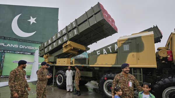 Солдат пакистанской армии позирует для фотографии с детьми перед пусковой установкой наземных баллистических ракет малой дальности Hatf-I во время военной выставки, проведенной в рамках празднования Дня независимости Пакистана в Исламабаде, Пакистан, 14 августа 2025 года.  - Sputnik Таджикистан
