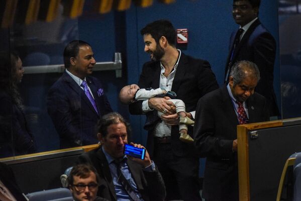 Навзод дар СММСоли 2018 ҷавонтарин иштирокчии вохӯрӣ кӯдаки семоҳа - духтари сарвазири Зеландияи Нав Ҷасинда Ардерн буд. Дар акс: Шавҳари Ҷасинда Ардерн, Кларк Гейфорд, духтари худ Неверо дар ассамблеяи генералии СММ 27 сентябри соли 2018 дар Ню Йорк рӯи даст гирифтааст. - Sputnik Тоҷикистон