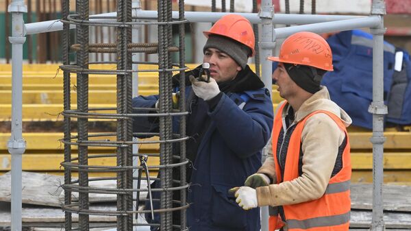 Рабочие вяжут арматуру на строительной площадке в Москве. - Sputnik Таджикистан