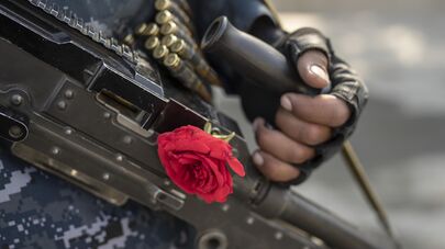 Боевик Талибана с розой на автомате обеспечивает безопасность в Кабуле, Афганистан, суббота, 4 декабря 2021 г.