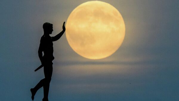 Луна восходит на горизонте за статуей Факелоносец (1937) на северном берегу озера Маш, Германия - Sputnik Таджикистан