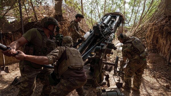 Украинские военнослужащие 148-й артиллерийской бригады загружают боеприпасы в гаубицу М777 перед стрельбой по российским позициям. Архивное фото - Sputnik Тоҷикистон