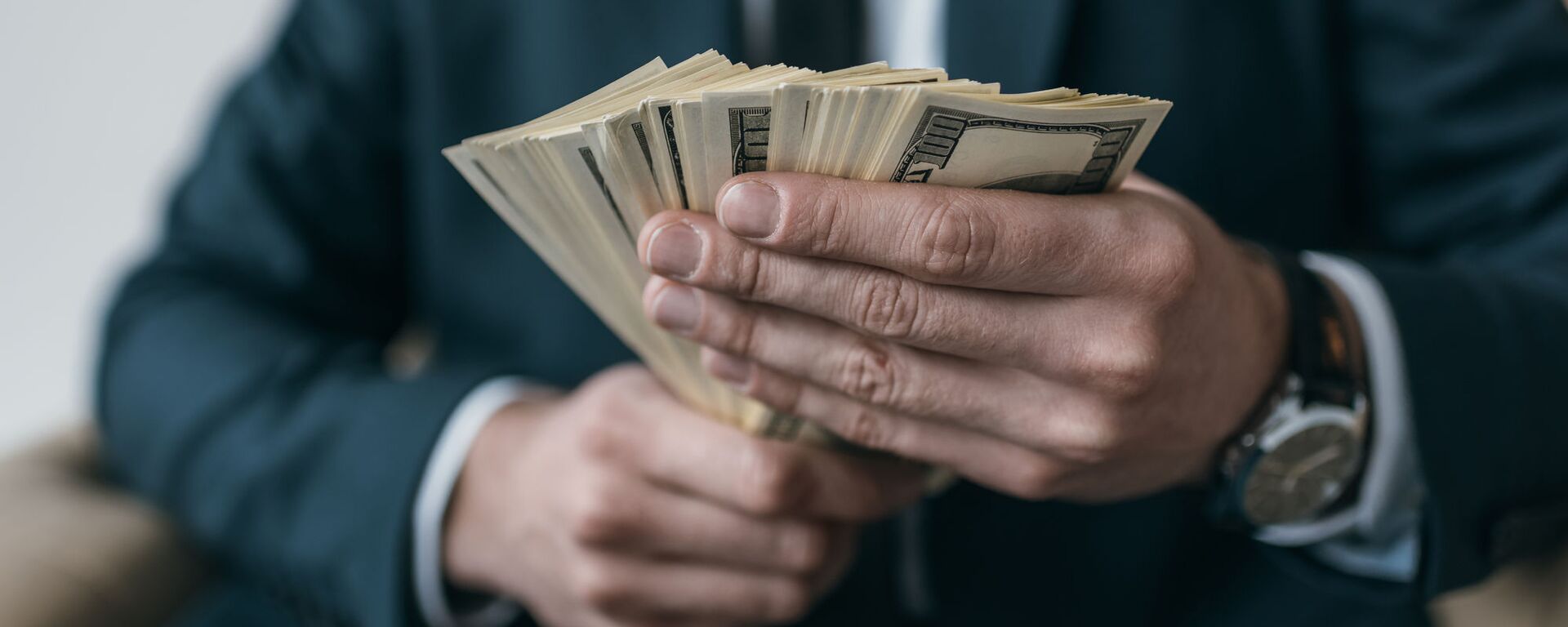 Бизнесмен с долларовыми купюрами - Sputnik Таджикистан, 1920, 19.11.2025