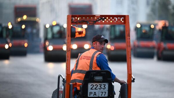 Рабочий во время работ по замене асфальтового покрытия на улице Тверской в Москве.  - Sputnik Тоҷикистон