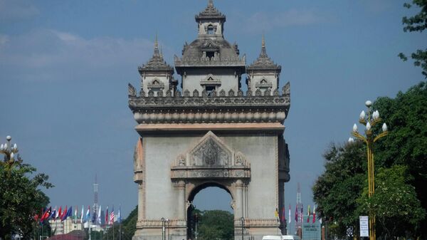 Автомобили проезжают перед монументом победы Патусай во Вьентьяне, Лаос. - Sputnik Тоҷикистон