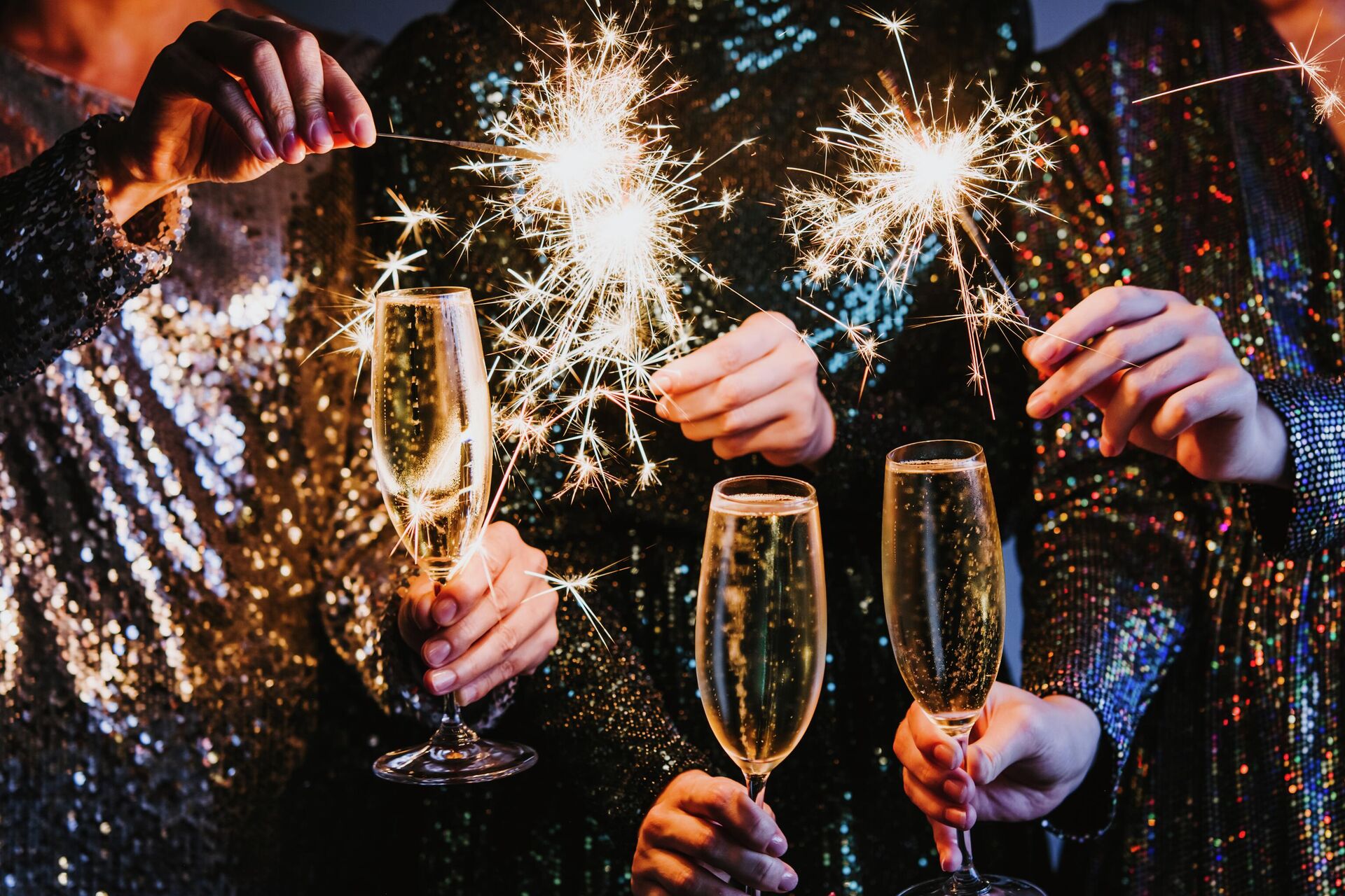 Друзья празднуют Рождество или Новый год с бенгальскими огнями и шампанским. - Sputnik Таджикистан, 1920, 27.11.2025