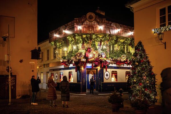 Мардум дар шаҳри қадимии Вилнюси Литва ороишоти солинавиро тамошо мекунанд. Мардум дар шаҳри қадимии Вилнюси Литва ороишоти солинавиро тамошо мекунанд. - Sputnik Тоҷикистон