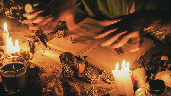 Руки гадалки над старинным столом с травами и книгами. Иллюстративное фото - Sputnik Таджикистан