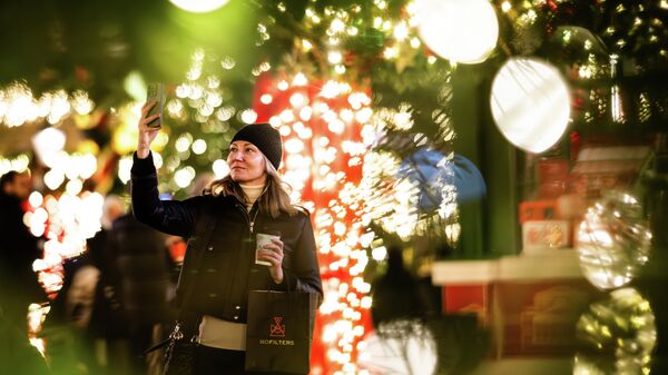 Девушка фотографируется на фоне новогодней инсталляции на одной из улиц в Москве. - Sputnik Таджикистан