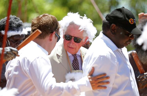 Принц Уэльский с повязкой на голове, украшенной перьями, — принимает участие в традиционной церемонии приветствия во время визита на гору Нхулун в Нхулунбуе, Северная территория Австралии. Принц Уэльский с повязкой на голове, украшенной перьями, — принимает участие в традиционной церемонии приветствия во время визита на гору Нхулун в Нхулунбуе, Северная территория Австралии. - Sputnik Таджикистан