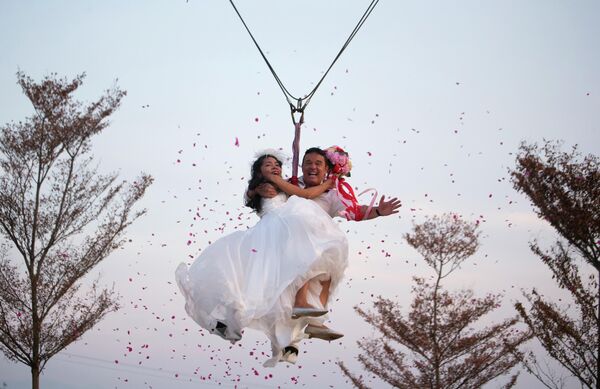 Невеста Чаруни Койдун и жених, британец Дэвид Лесли Честерман, празднуют День святого Валентина, поднявшись в небо на "небесных американских горках" в рамках приключенческой свадебной церемонии в провинции Ратчабури, Таиланд, в субботу, 13 февраля 2016 года, накануне Дня святого Валентина. Невеста Чаруни Койдун и жених, британец Дэвид Лесли Честерман, празднуют День святого Валентина, поднявшись в небо на "небесных американских горках" в рамках приключенческой свадебной церемонии в провинции Ратчабури, Таиланд, в субботу, 13 февраля 2016 года, накануне Дня святого Валентина. - Sputnik Таджикистан