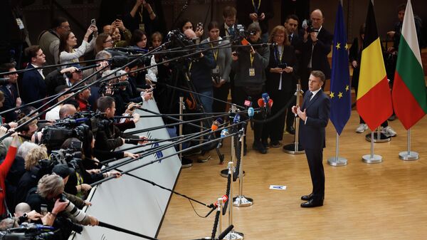 Президент Франции Эммануэль Макрон общается с представителями СМИ по прибытии на саммит ЕС в Брюссель в четверг, 18 декабря 2025 года.  - Sputnik Тоҷикистон