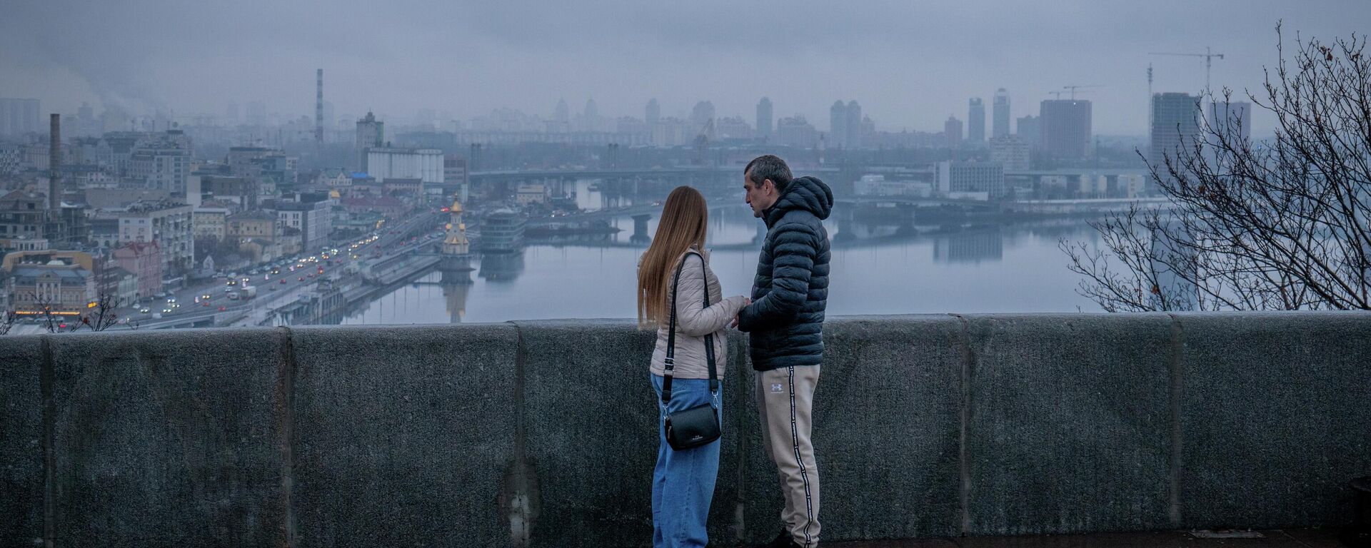Пара стоит на мосту в Киеве, Украина, понедельник, 1 декабря 2025 года. - Sputnik Таджикистан, 1920, 24.12.2025