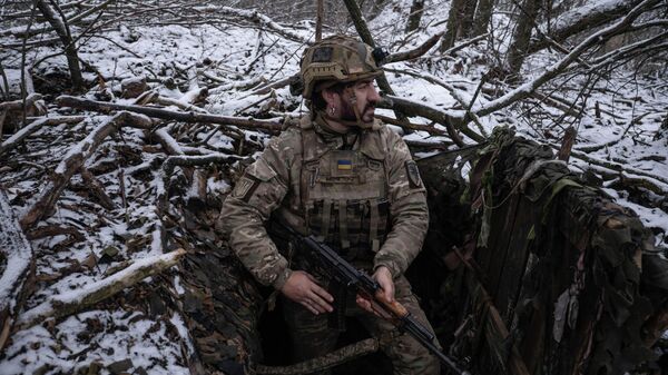 Украинский солдат осматривает позиции вблизи прифронтового города Константиновка 16 декабря 2025 года.  - Sputnik Тоҷикистон