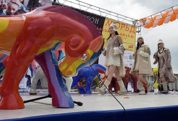 Монгольские модели в войлочных нарядах проходят мимо красочно раскрашенной лошади во время выставки работ детей в Улан-Баторе, Монголия, 2006 год. Ребята из различных провинций страны помогли раскрасить 88 статуэток лошадей в рамках программы, направленной на предоставление детям доступа к художественным ресурсам. - Sputnik Таджикистан