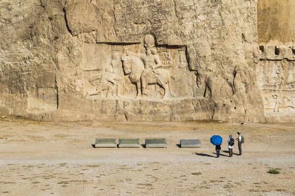 Тамошобинон тасвири пирӯзии Шопури I бар императори Рум Валериан ва Филиппи Арабистонро тасвир мекунад; Нақши Рустам, вилояти Форс, Эрон. Тамошобинон тасвири пирӯзии Шопури I бар императори Рум Валериан ва Филиппи Арабистонро тасвир мекунад; Нақши Рустам, вилояти Форс, Эрон. - Sputnik Тоҷикистон